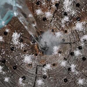 Image: Hot water being poured into drilled hole to dissolve salt.